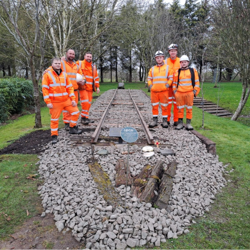 group of men after completing volunteering project to restore a piece of track from the Thai Burma Railway Memorial
