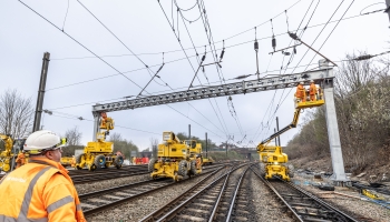 Rail operative looking up at an overhead line gantry being installed by VolkerRail using MEWPS and road rail vehicles on the Transpennine route upgrade project 