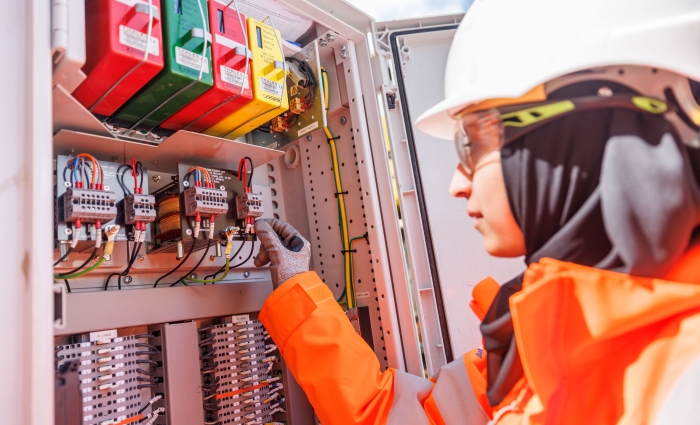 women working on cables on site in the sunshine