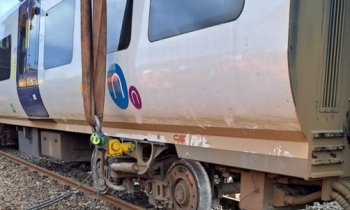 A passenger train being rerailed using a Kirow crane