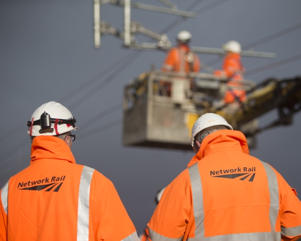 two people with PPE back to camera