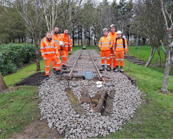 group of men after completing volunteering project to restore a piece of track from the Thai Burma Railway Memorial